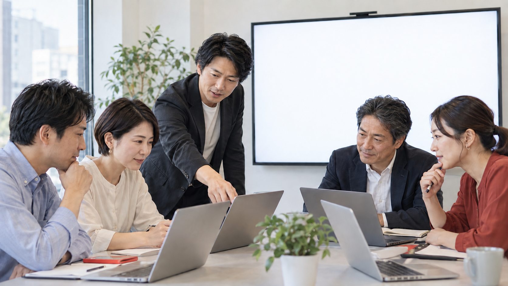 講師と企業の担当者がパソコンを使いながら生成AI研修に取り組む様子